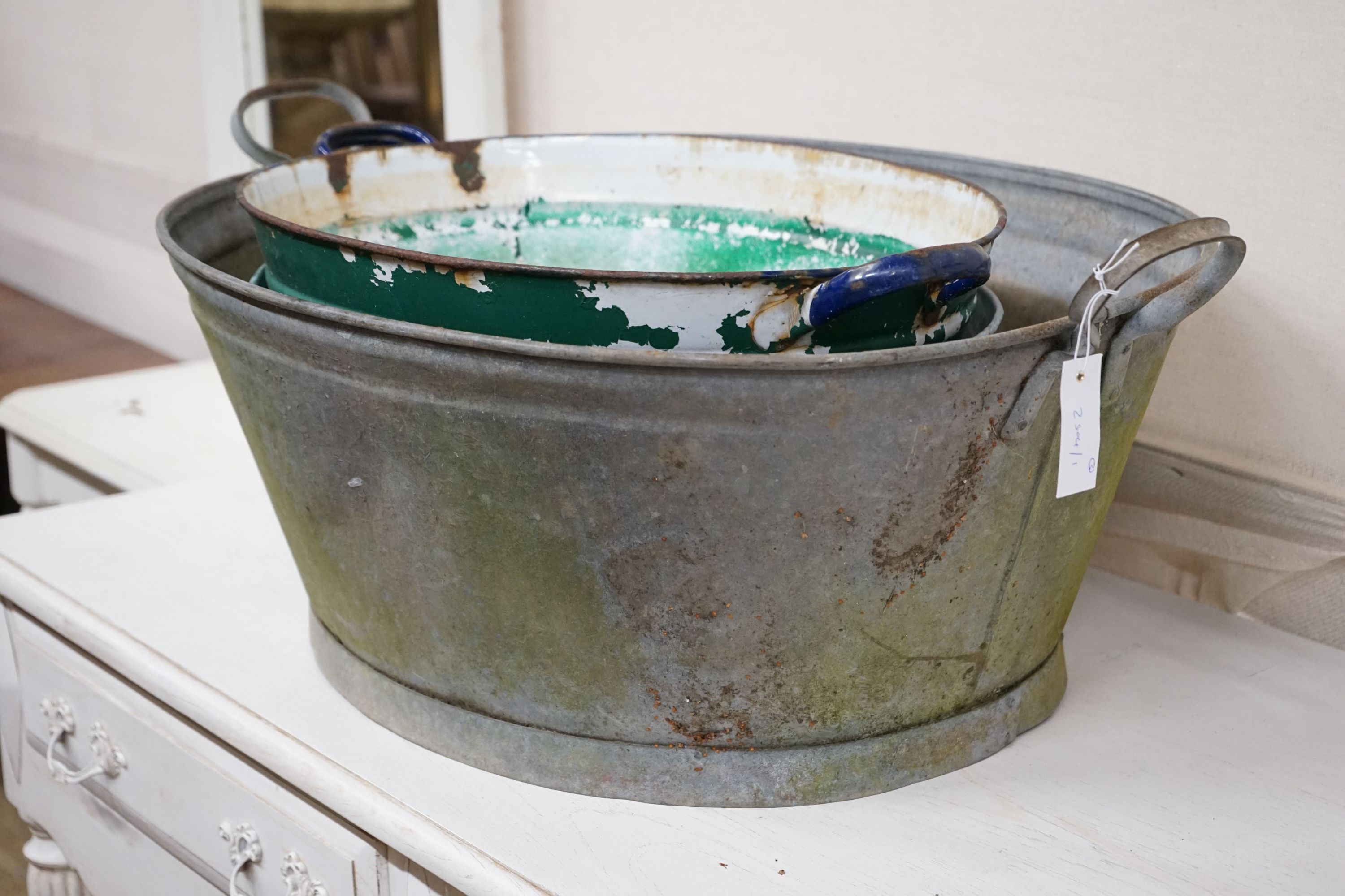 Three oval enamel and galvanised containers, largest width 88cm